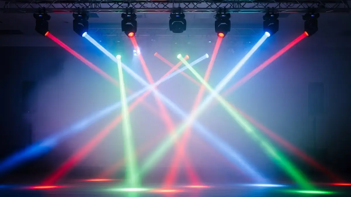 Cabezas móviles con haces de colores montadas en una estructura de truss sobre el escenario