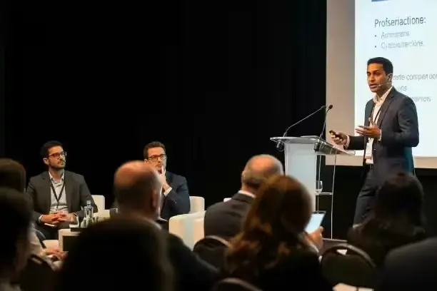 Ponente en un podium con micrófono frente al público de una conferencia
