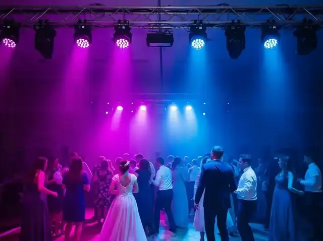 Pista de baile de boda iluminada por cabezas móviles en tonos magenta y azul montadas en truss
