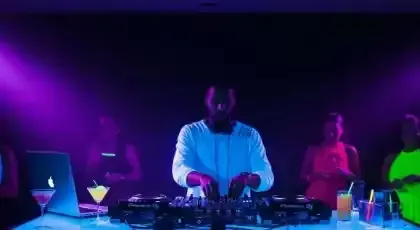 DJ en una fiesta iluminada con luz neón violeta y azul