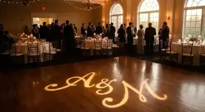 Monograma de novios proyectado con gobo sobre la pista de baile de un salón